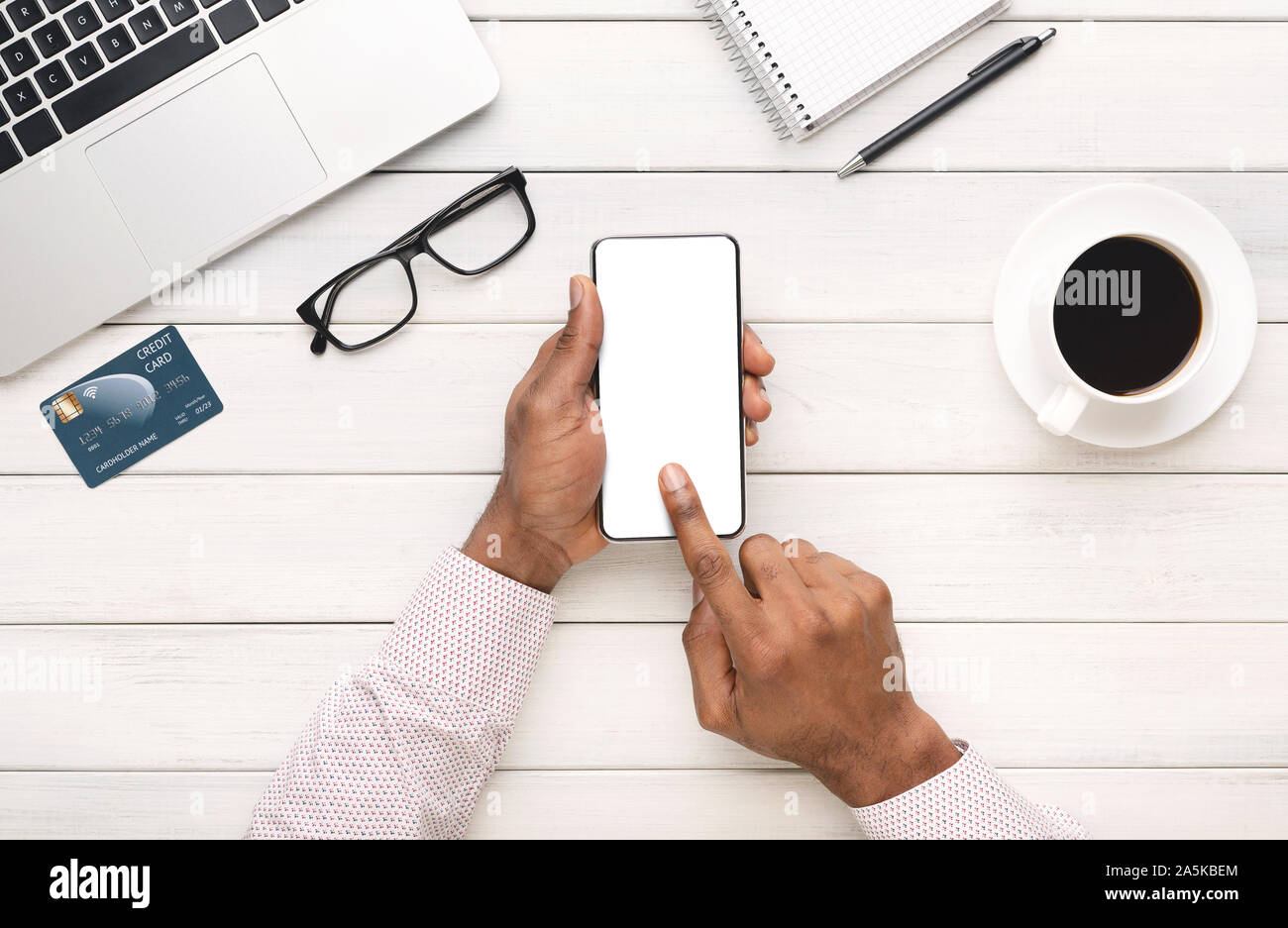 Schwarze Hände mit leerer Bildschirm am Arbeitsplatz smartphone Stockfoto