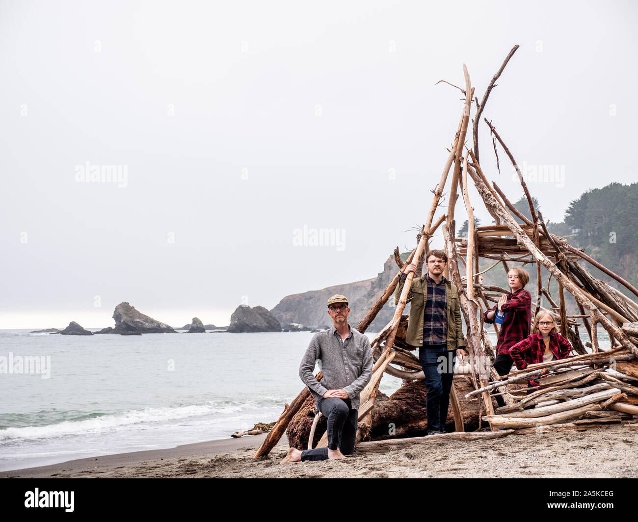 Jungen und Männer in treibholz Struktur auf einem California Beach Stockfoto