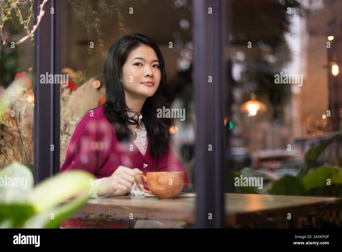 Frau, die durch Fenster im café Stockfoto