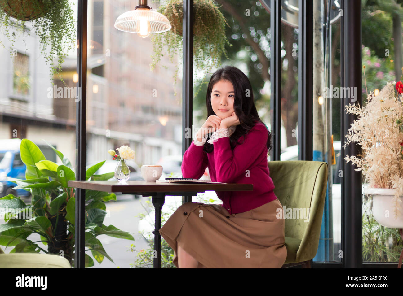 Frau sitzt an einem Tisch in Cafe Stockfoto