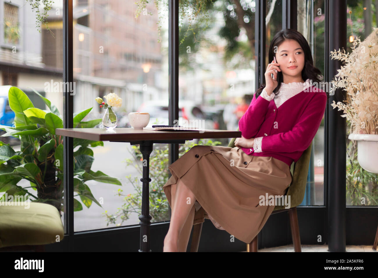 Frau am Telefon im café Stockfoto