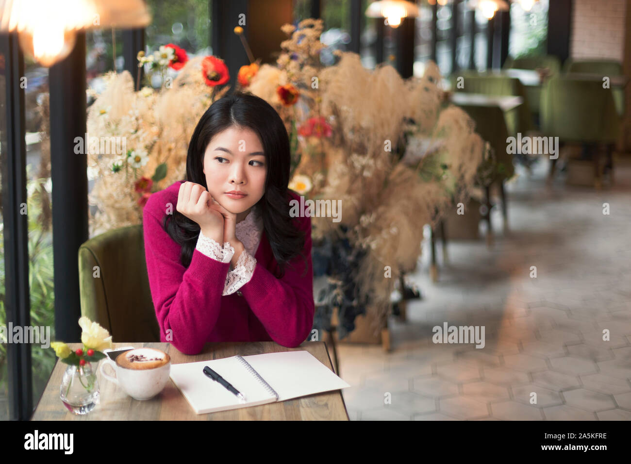 Frau sitzt an einem Tisch in Cafe Stockfoto