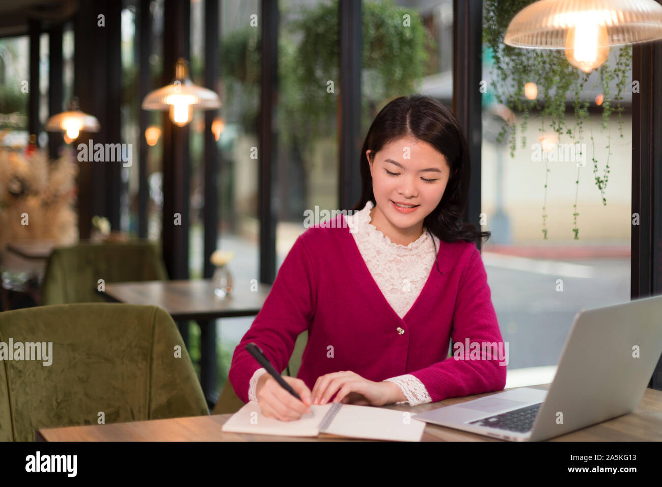 Frau schreiben in der Anwendung "Notizen" im Cafe Stockfoto