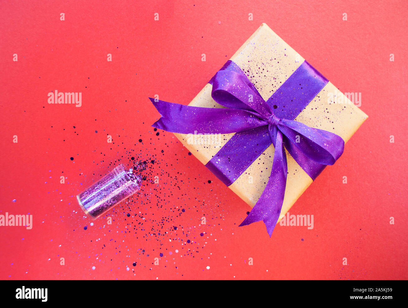 Geschenkset mit lila Farbe ribbon auf dunklem Hintergrund rot mit Glitzer gebunden. Flach Stil. Stockfoto