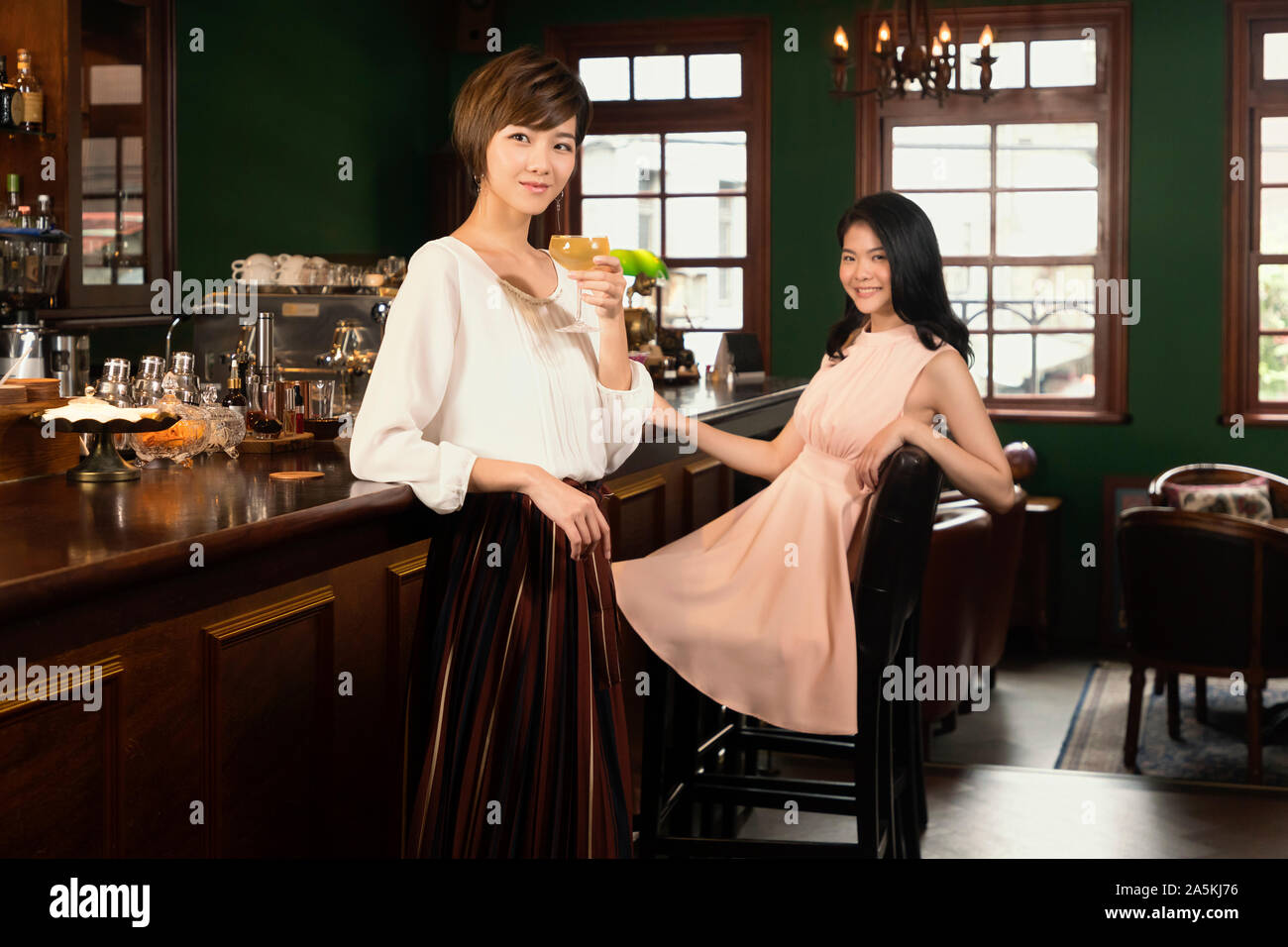 Porträt von zwei jungen Frauen entspannen und Cocktails an der Bar Stockfoto