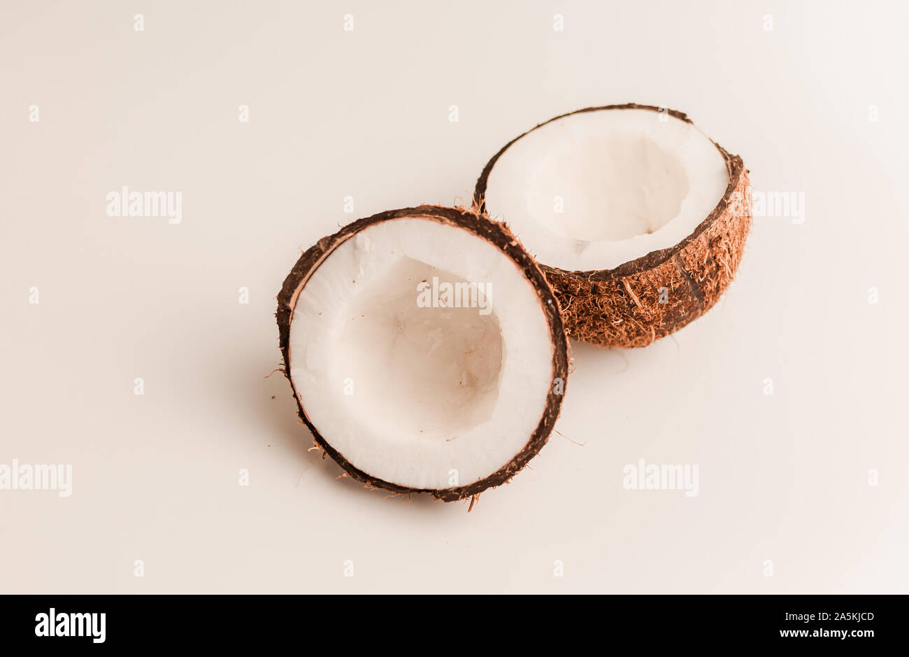 Hässliche organische Kokosnuss auf einem weißen Hintergrund, isolieren. Eine gebrochene Mutter in einer Shell den weißen Innenseiten einer Kokosnuss, begann zu zerfallen und mit abgedeckten Stockfoto