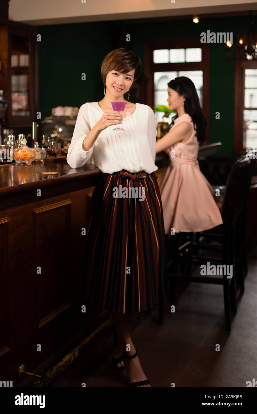 Porträt der jungen Frau Rosa Cocktail an der Bar genießen, Zähler Stockfoto