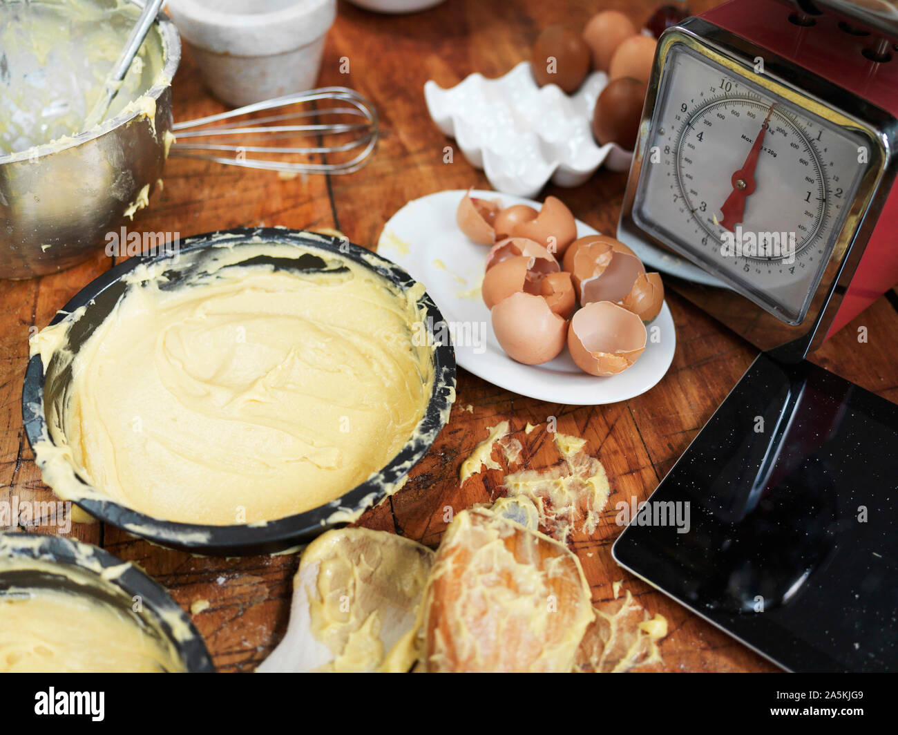 Unordentliche backen Zubereitung am Tisch mit Kuchen, Mischung, Küchenwaagen, Küchengeräte und digitale Tablet Stockfoto