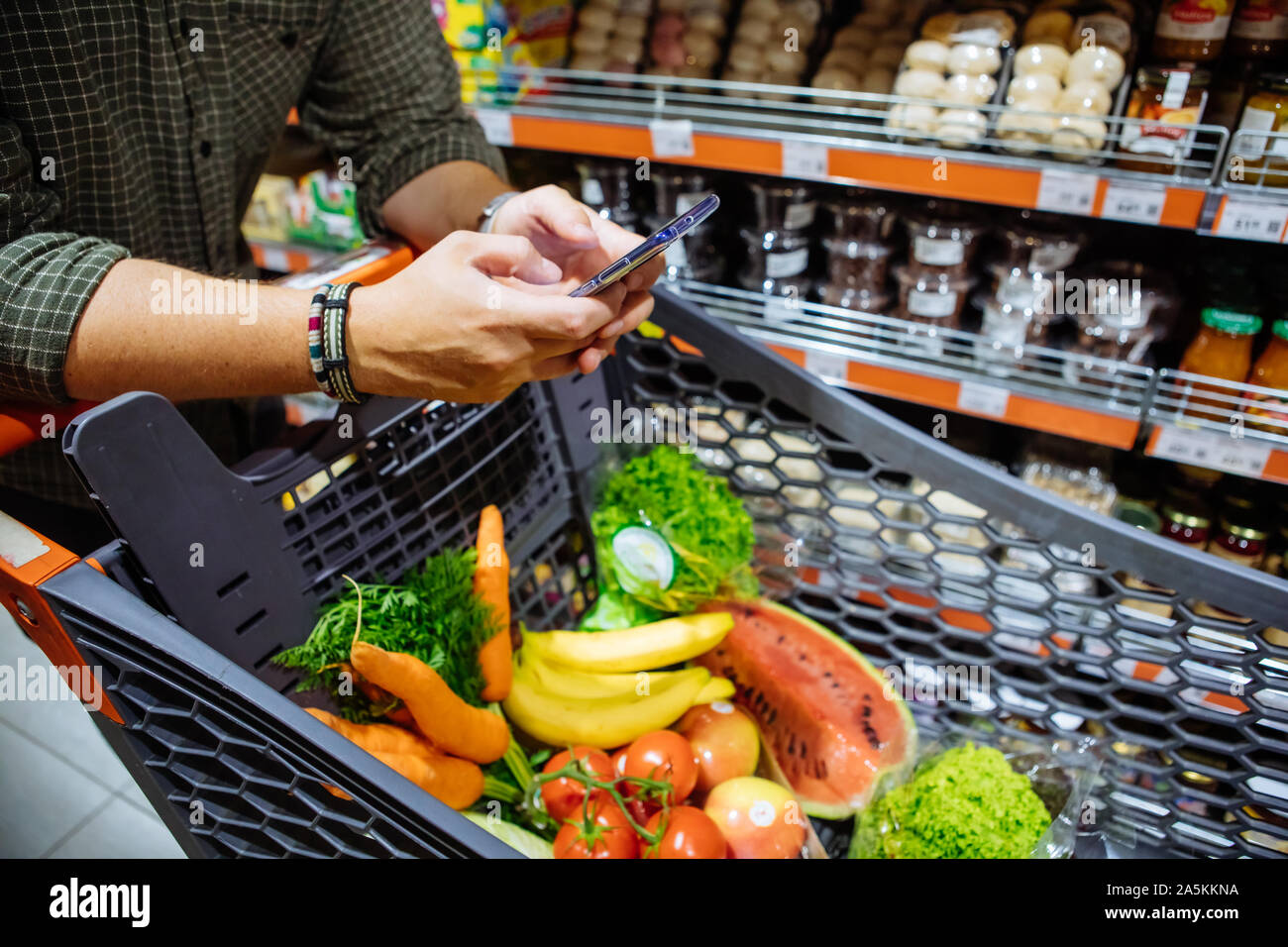 Mann mit Smartphone Einkaufen im Supermarkt Stockfoto