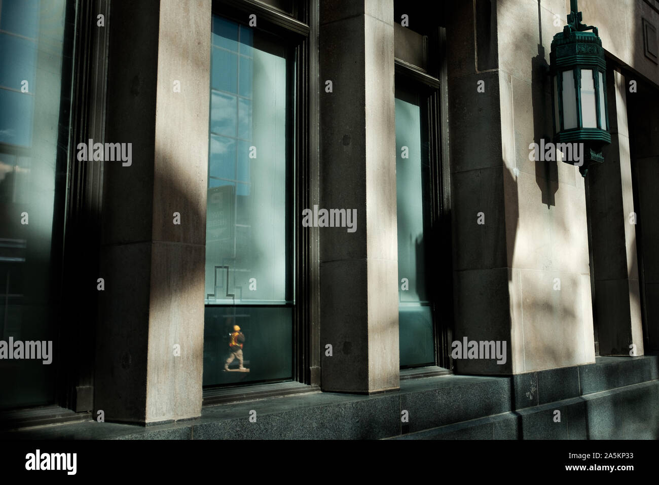 London, Kanada - 18. Oktober 2019. Ein Bauarbeiter ist im Fenster eines Bürogebäudes wider. Stockfoto