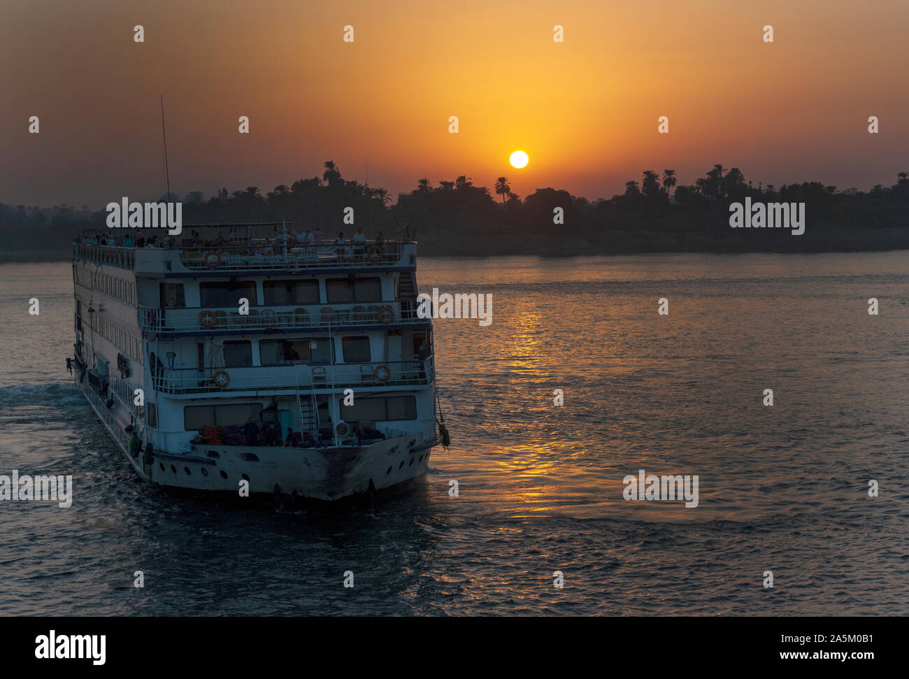Nil Kreuzfahrt Schiffe Ansatz Kom Ombo mit der Sonne über die West Bank, der Nil, Ägypten, Afrika. Stockfoto