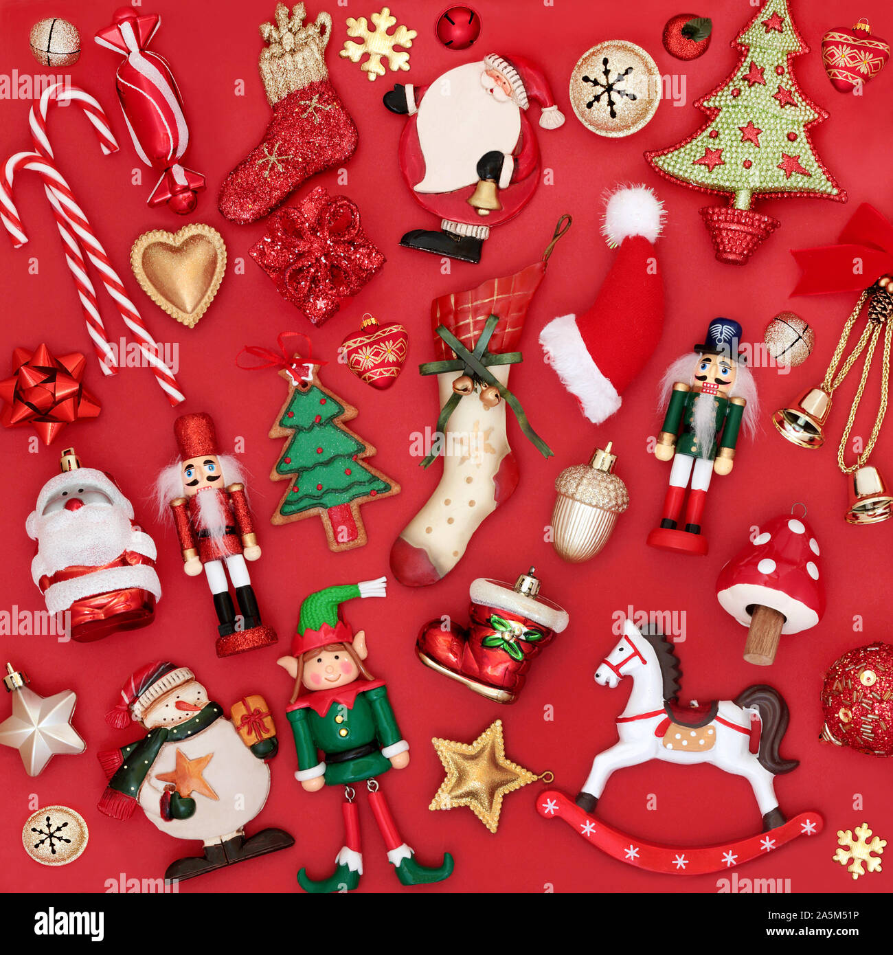 Weihnachten Dekorationen und Baumschmuck auf rotem Hintergrund. Traditionelle Thema mit Symbolen für die festliche Jahreszeit. Stockfoto