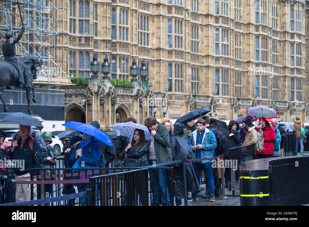 Mitglieder der Öffentlichkeit warten außerhalb der Besucher Eingang zum Palast von Westminster, London, UK Stockfoto