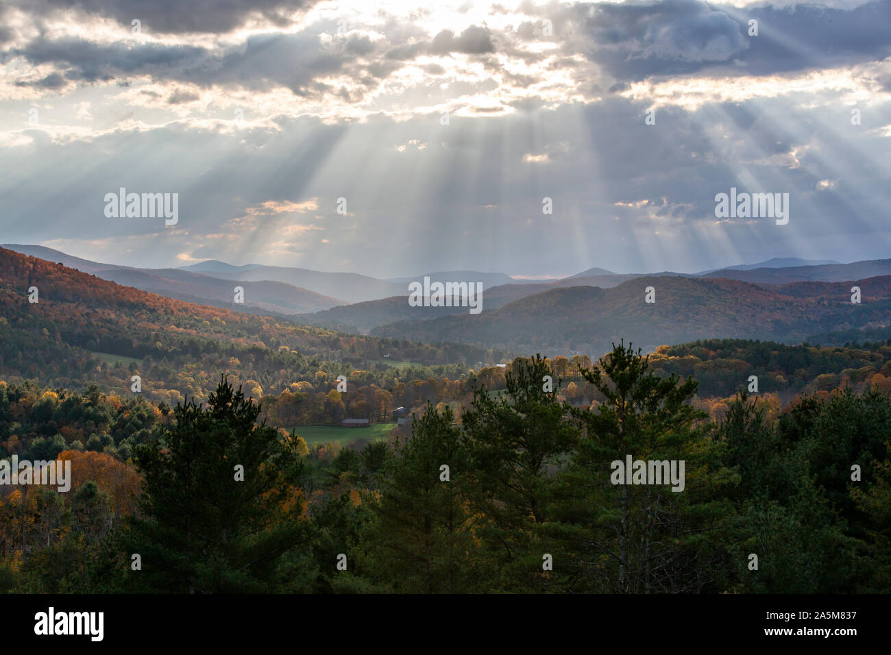 Sonnenlicht Strahlen durch die Wolken über den Bergen in Quechee, Vermont. Stockfoto