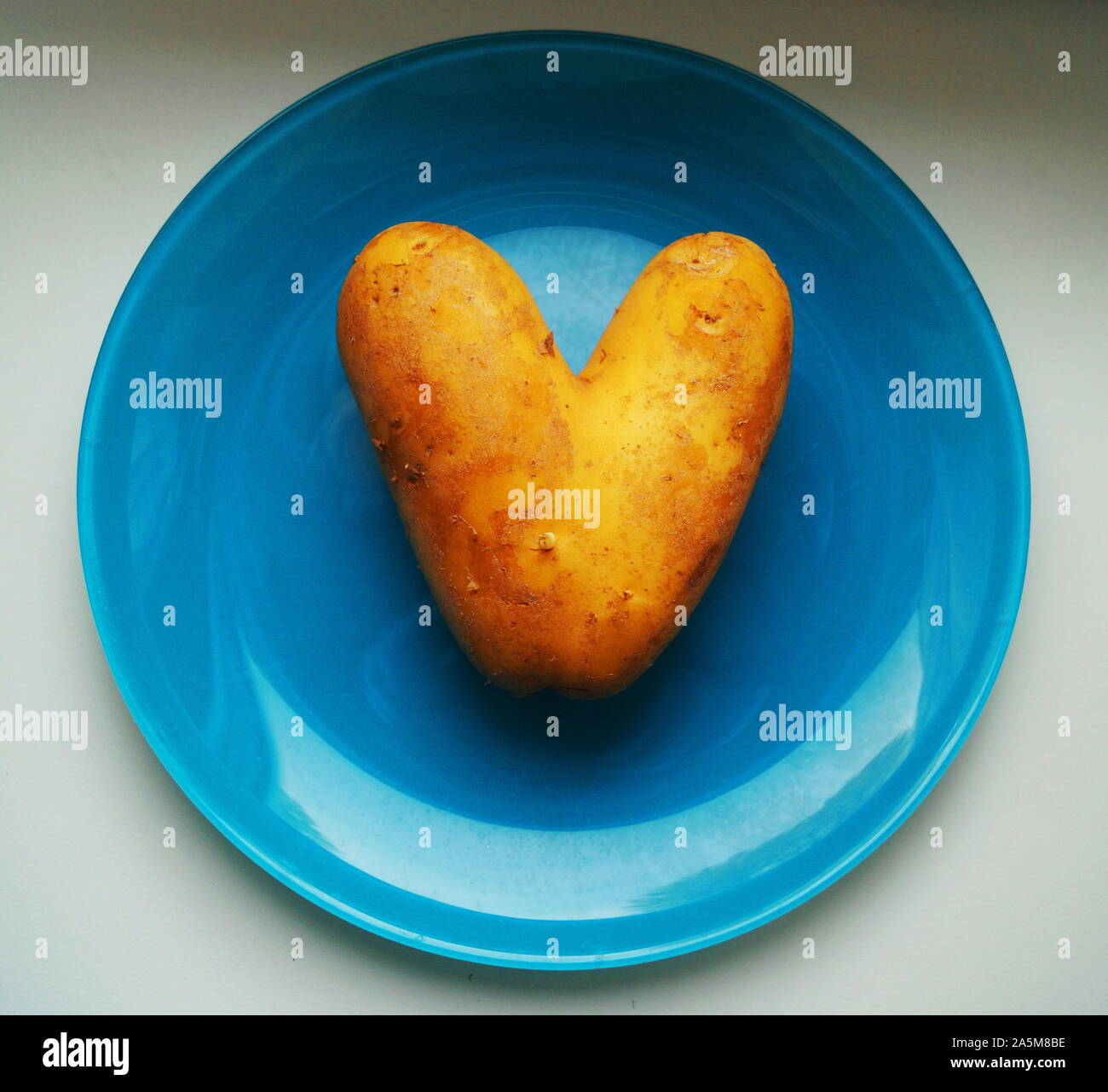 Eine Kartoffel Herzen auf einer blauen Platte Stockfoto