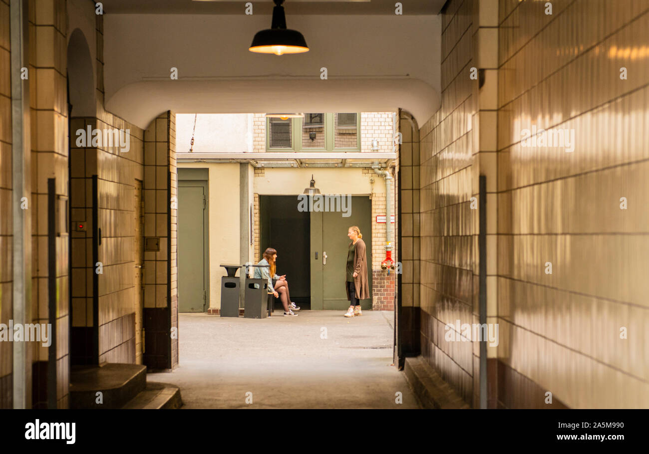 Kollegen sprechen in Back Lane von Bürogebäude, Checkpoint Charlie, Berlin, Deutschland, Großbritannien Stockfoto