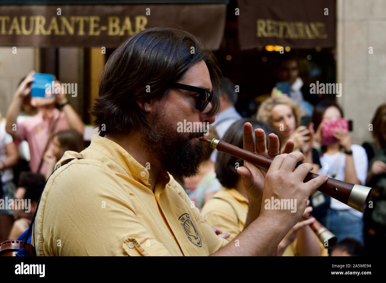 Ein Mann spielen Sie auf einem Instrument, das an die Riesen Parade während La Merce Festival 2019 am Placa de Sant Jaume in Barcelona, Spanien Stockfoto