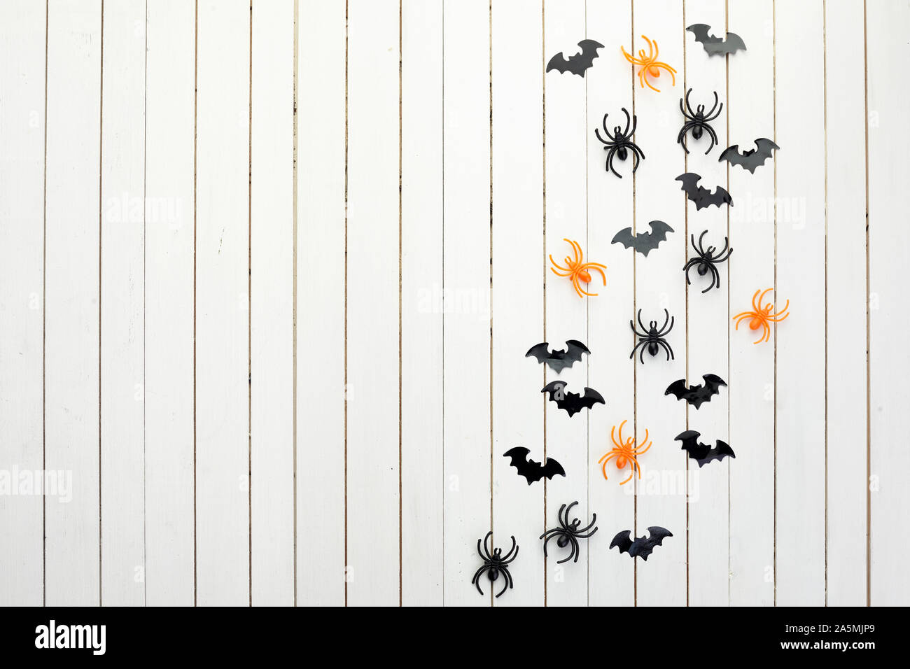 Halloween, Dekoration und beängstigend Konzept. Schwarzes Papier Fledermäuse und Spinnen auf weißem Holz- Hintergrund Stockfoto