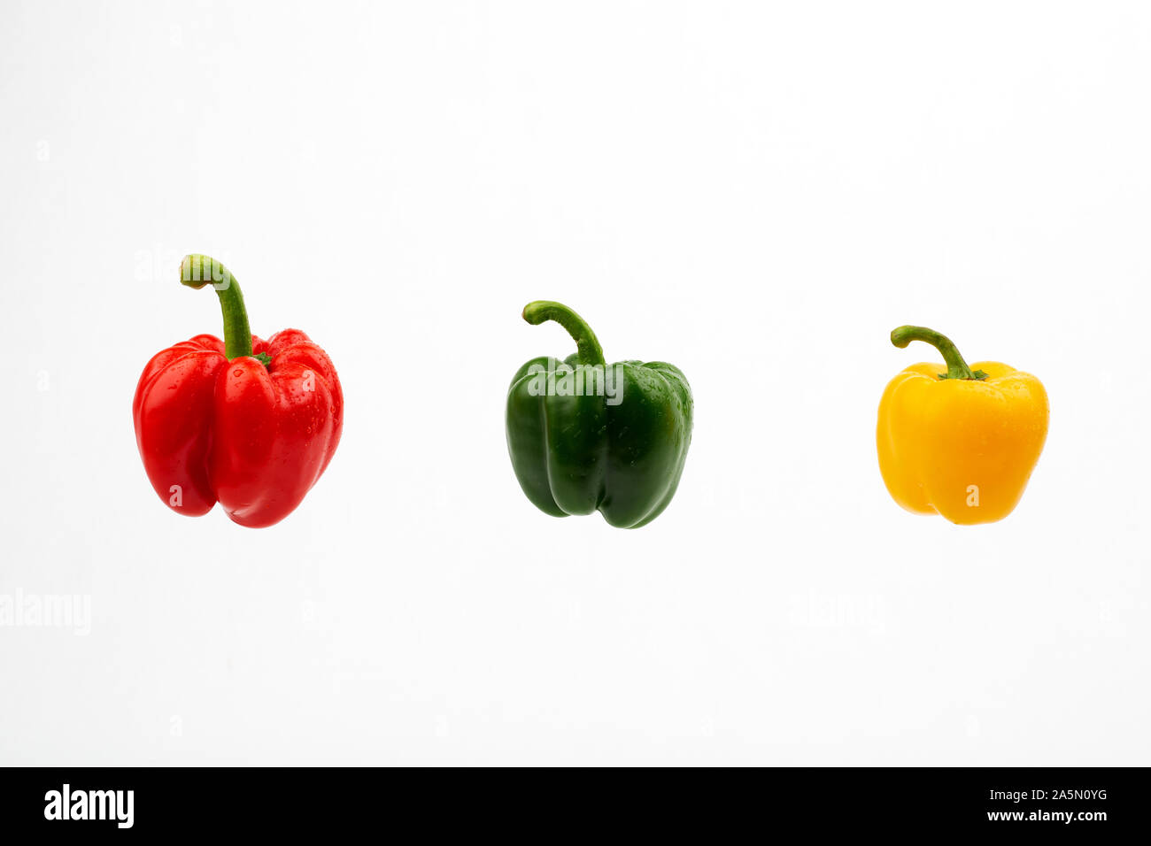 Grüne Rote und gelbe Paprika auf weißem Hintergrund Stockfoto