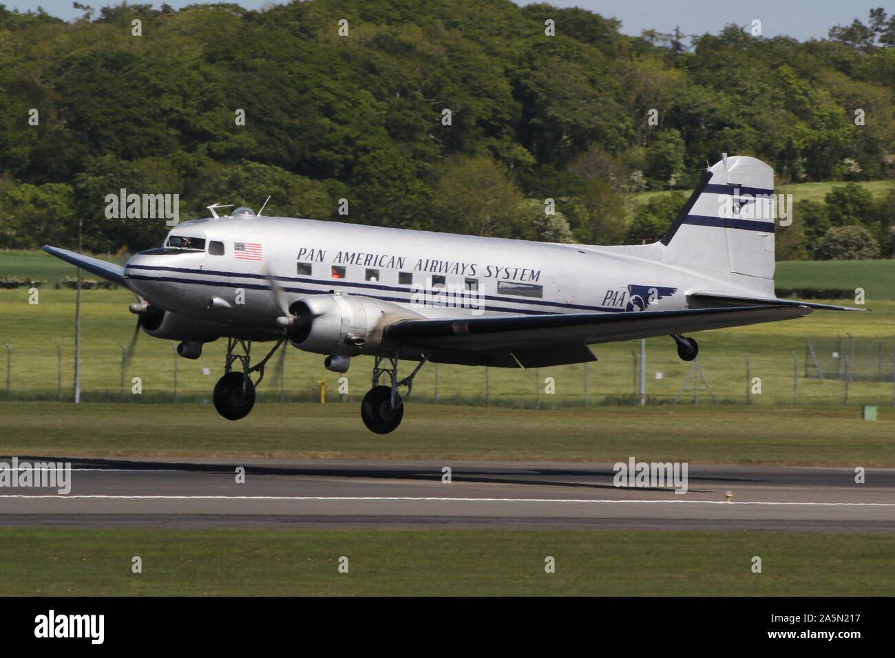 N 877 MG, eine Douglas DC-3 Dakota in der Pan American Airways Farben, die durch Prestwick Airport in Ayrshire, vorbei an den Daks über der Normandie Veranstaltung zu besuchen. Stockfoto