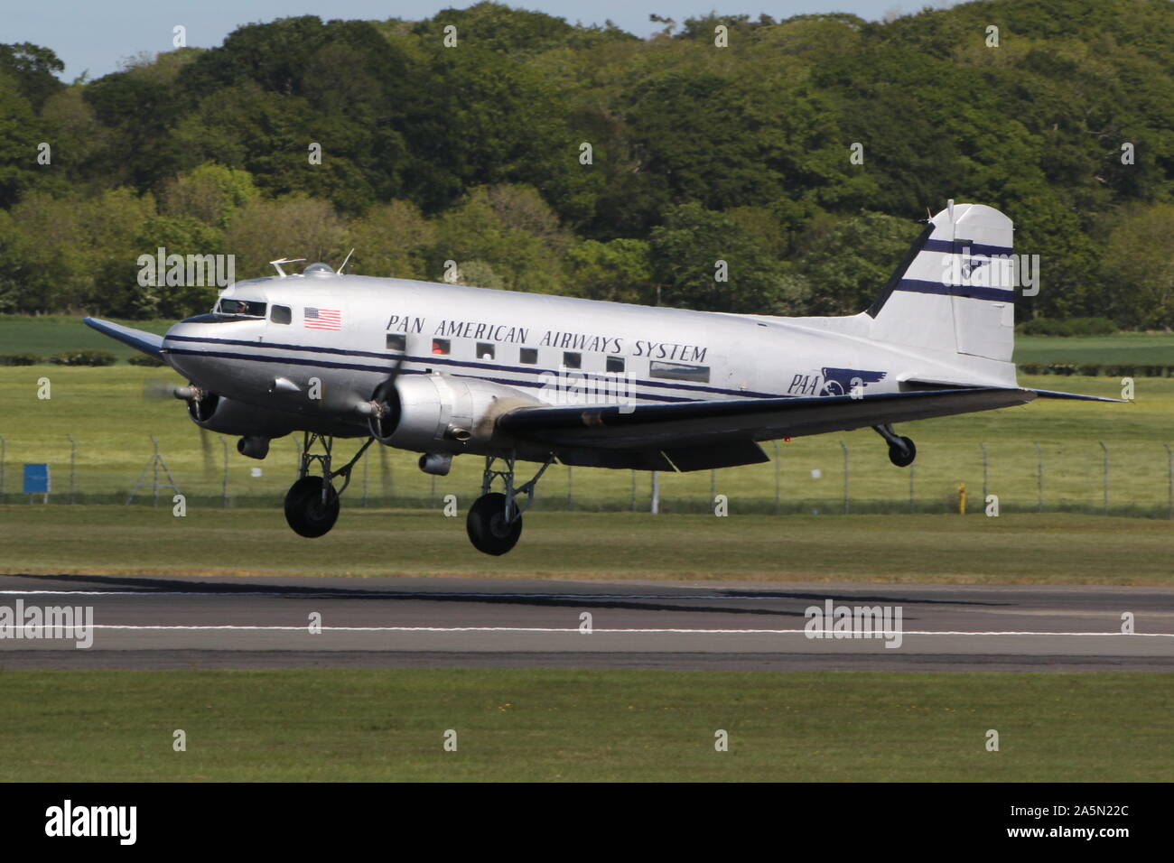 N 877 MG, eine Douglas DC-3 Dakota in der Pan American Airways Farben, die durch Prestwick Airport in Ayrshire, vorbei an den Daks über der Normandie Veranstaltung zu besuchen. Stockfoto