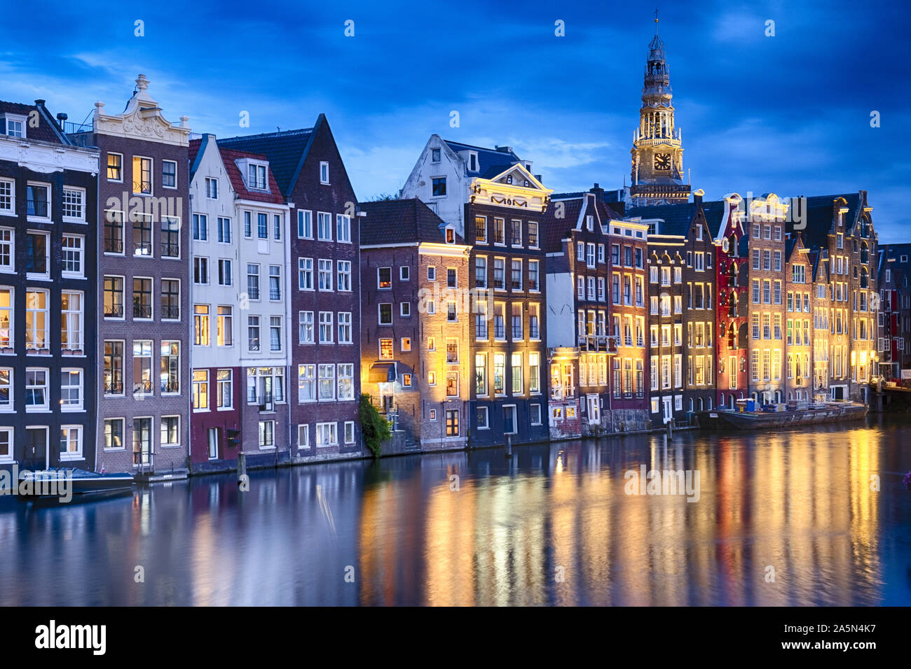 Amsterdam beleuchtet bei Dämmerung mit der Oude-Kirche im Hintergrund, Nordholland, Niederlande Stockfoto
