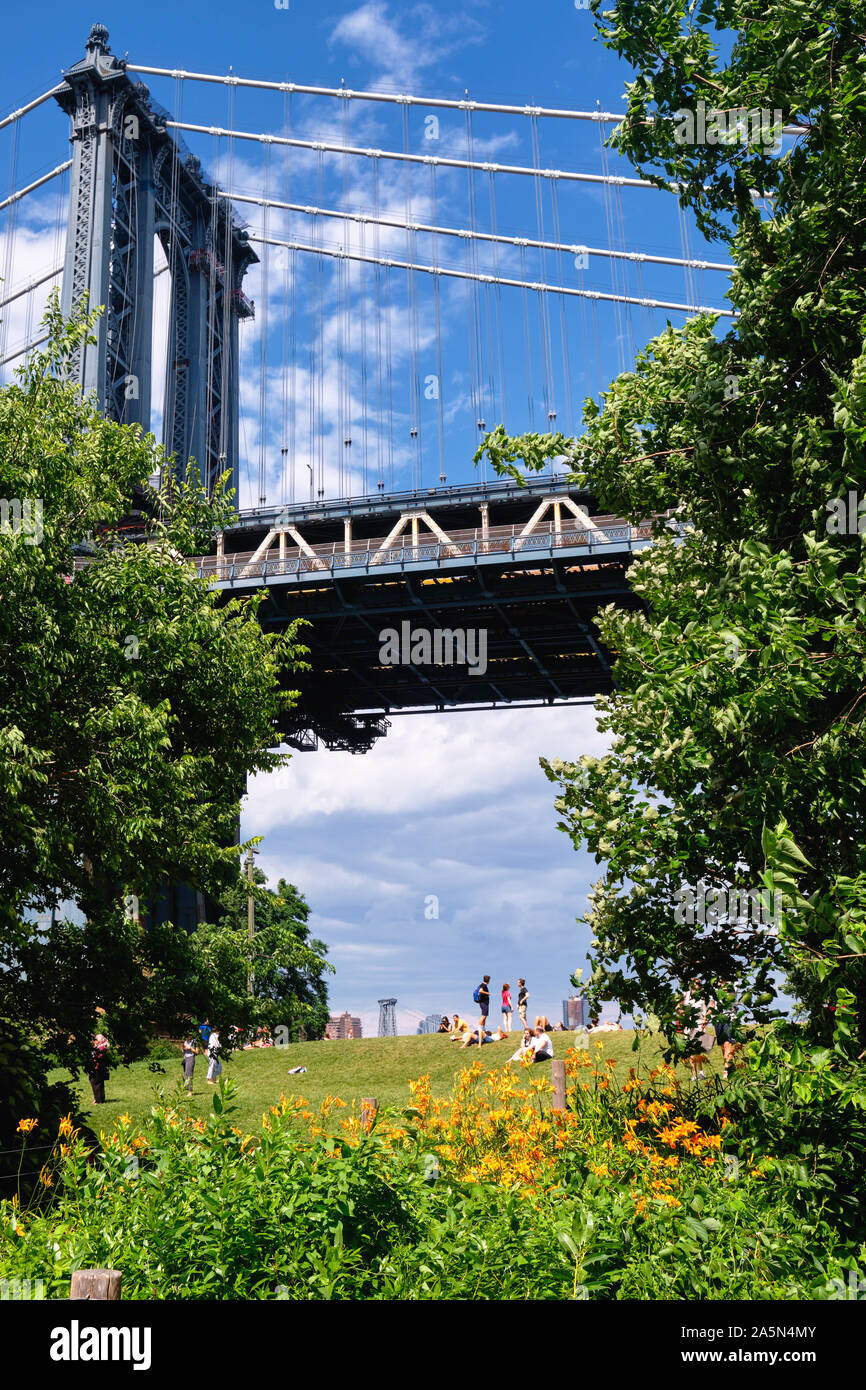 Die Menschen sind sich in der Main Street Park unter dem die Manhattan Bridge, New York City Stockfoto