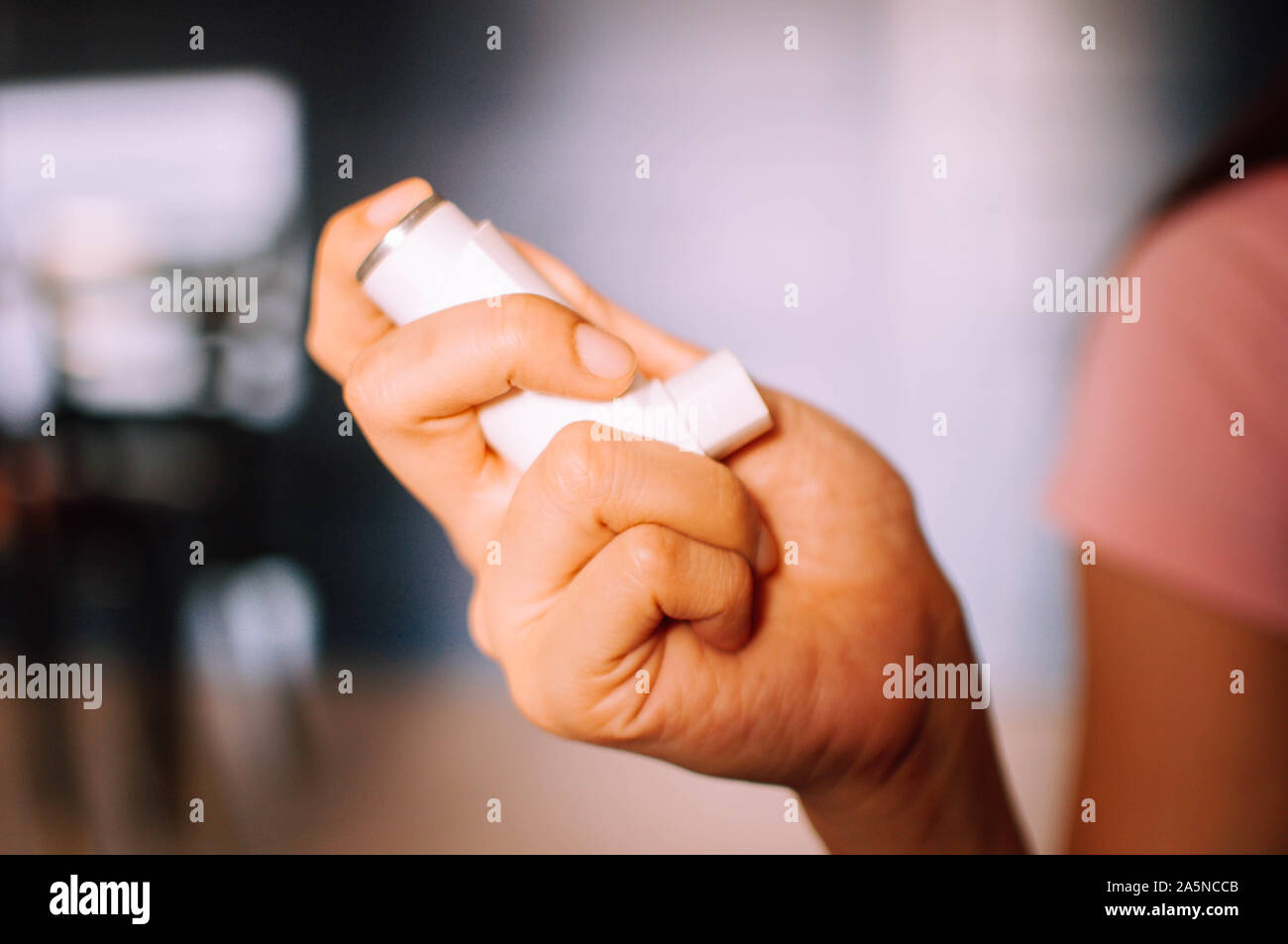 Eine junge Frau wird mit Hilfe eines Asthma Inhalator Gerät innen Stockfoto