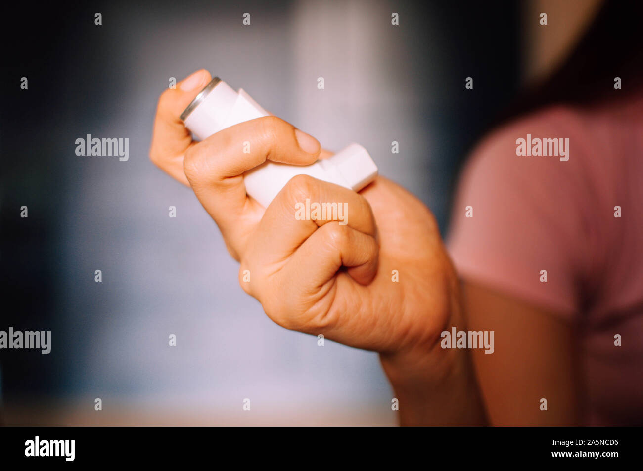 Eine junge Frau wird mit Hilfe eines Asthma Inhalator Gerät innen Stockfoto