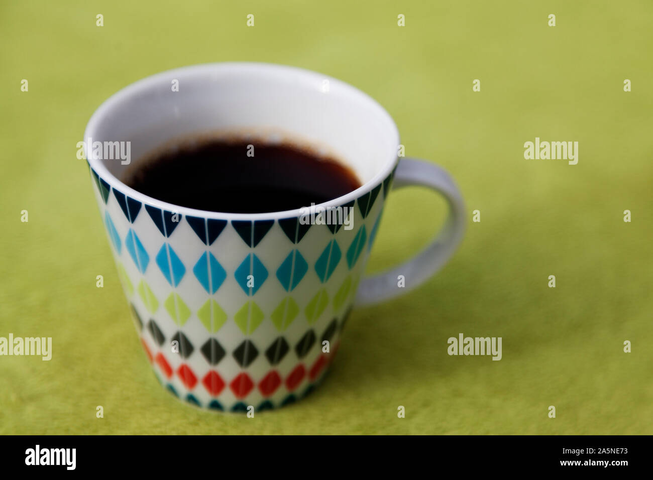 Heißer Kaffee in einer schönen Schale stehen auf grün Picknick Stoff in der Natur in Umea Stockfoto