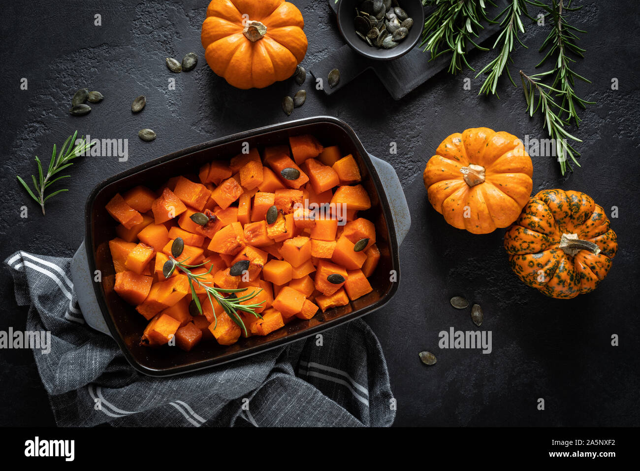 Gebratene Kürbisscheiben mit Rosmarin und Samen, gesunde, vegetarische Nahrung, Ansicht von oben Stockfoto