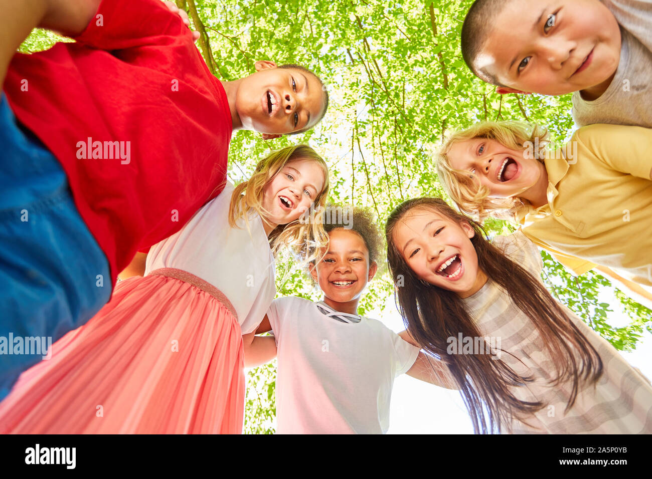 Multikulturelle Kinder lachen zusammen für Teamgeist und Integration Stockfoto