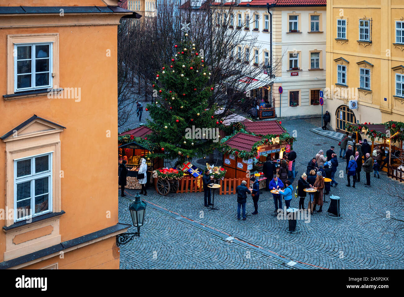 Menschen essen Essen auf kleinen gepflasterten Platz für Winterurlaub während der traditionelle Weihnachtsmarkt in Prag. Stockfoto