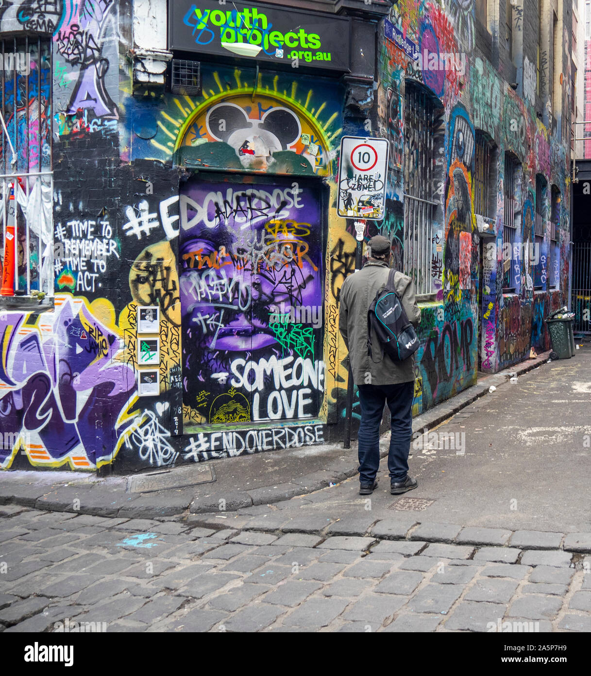 Man Walking in Hosier Lane und Rutledge Gasse Wände in Graffiti und Street Art Melbourne Victoria Australien abgedeckt. Stockfoto