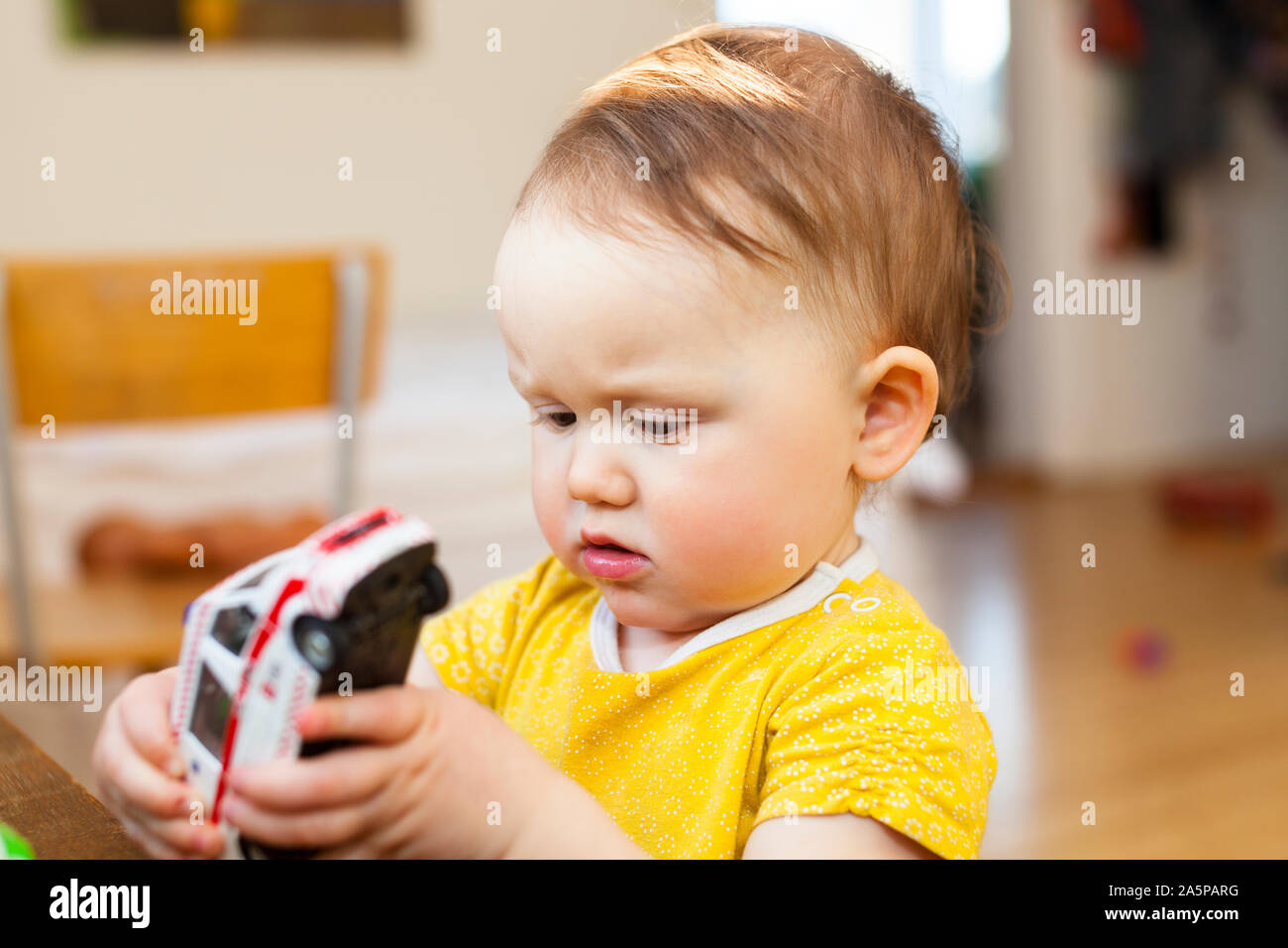 Baby spielt mit Spielzeug-Auto Stockfoto