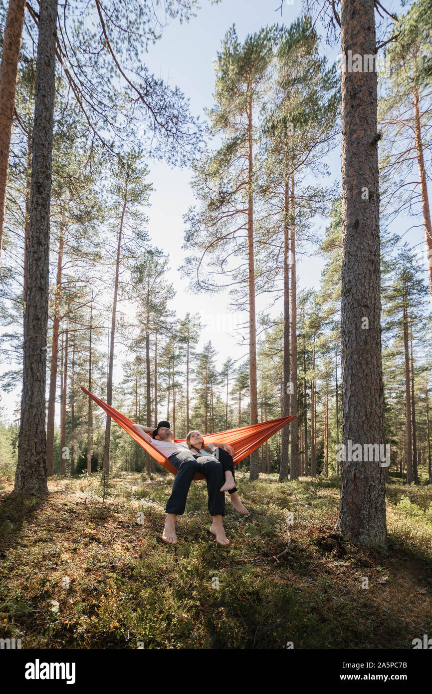 Junges Paar in einer Hängematte im Wald liegen Stockfoto