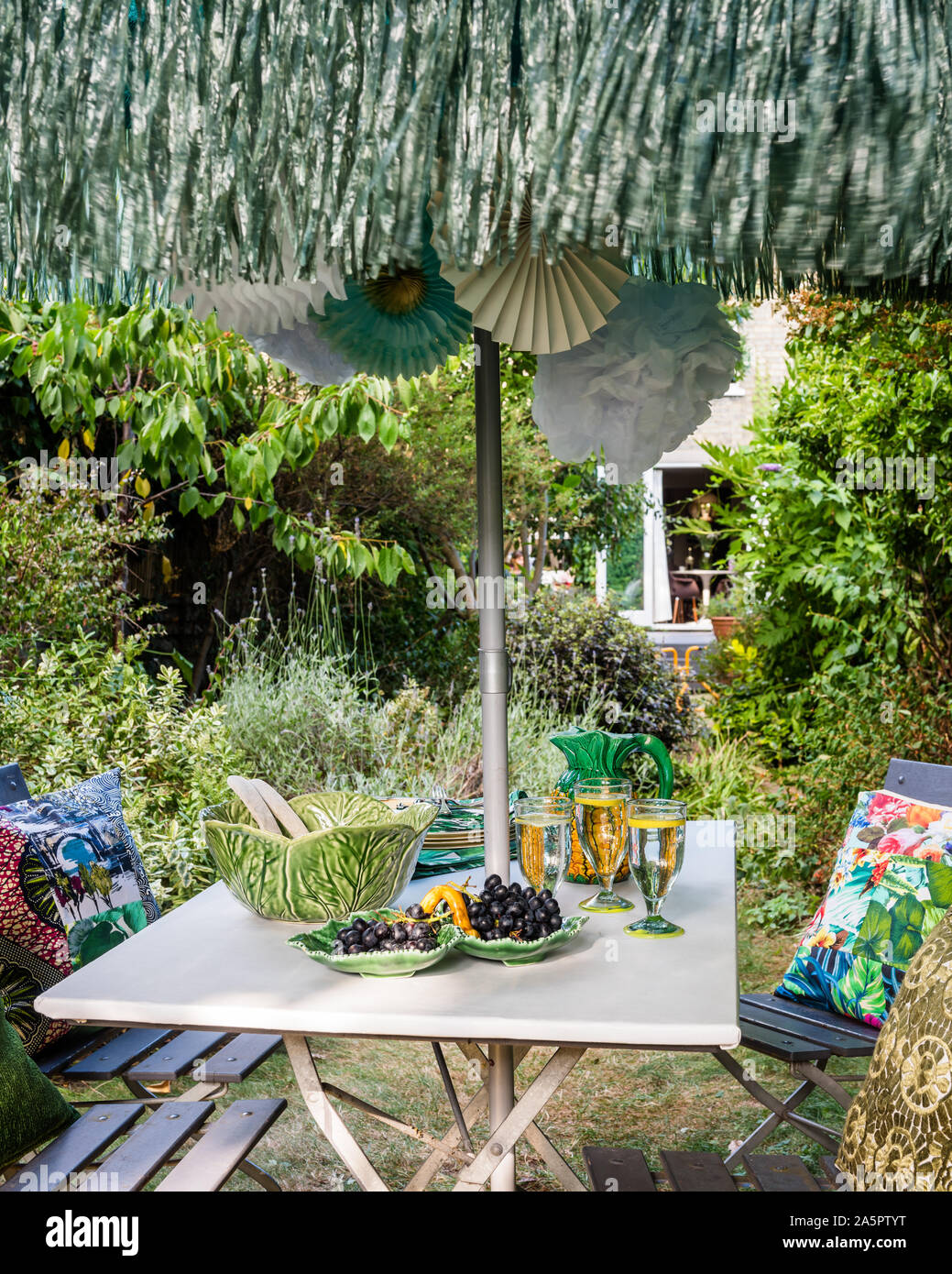 Garten Tisch mit Sonnenschirm und Kissen von Secondavita Stockfoto