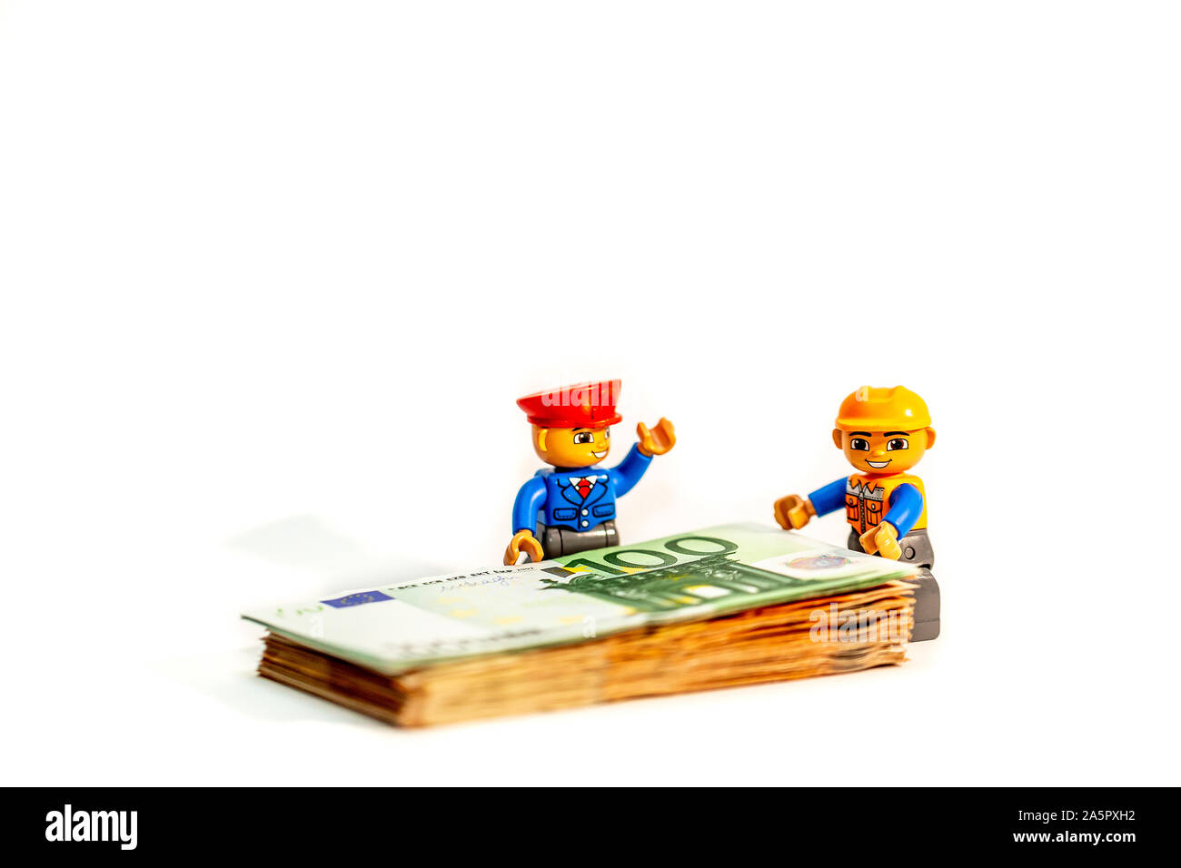 Legoland Spielzeug Arbeiter Modell stehen einer pilo von Euro-banknoten, Geld. Lego Minifiguren sind von der Lego Gruppe hergestellt Stockfoto