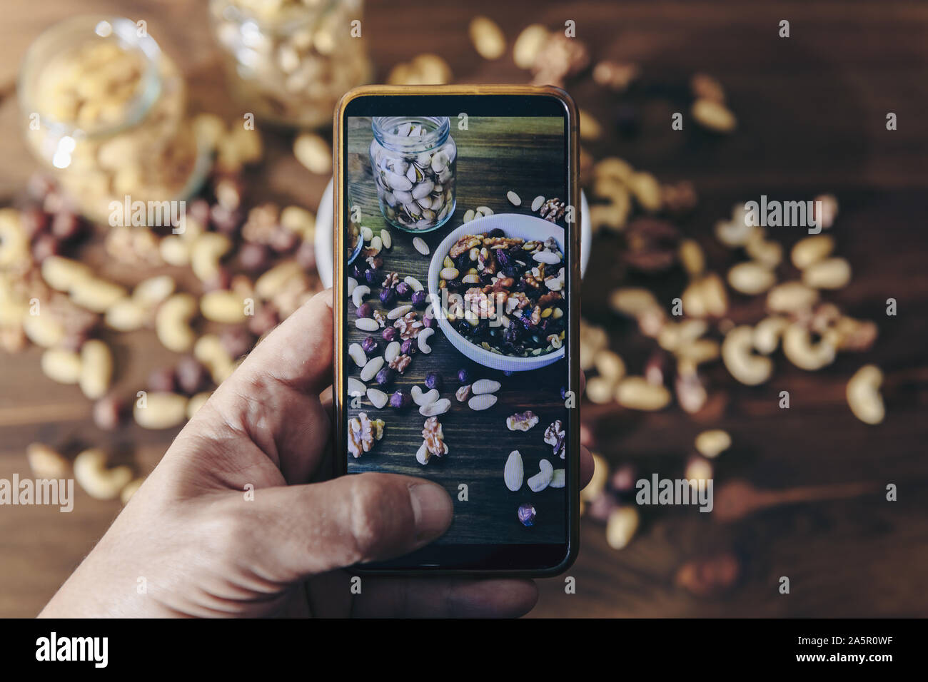 Essen blogger, Foto blog, pic in eine Schüssel mit gemischten Bio Trockenfrüchte und Gläser mit gemischten Nüssen auf rustikalen Holztisch, gesundes Essen Stockfoto