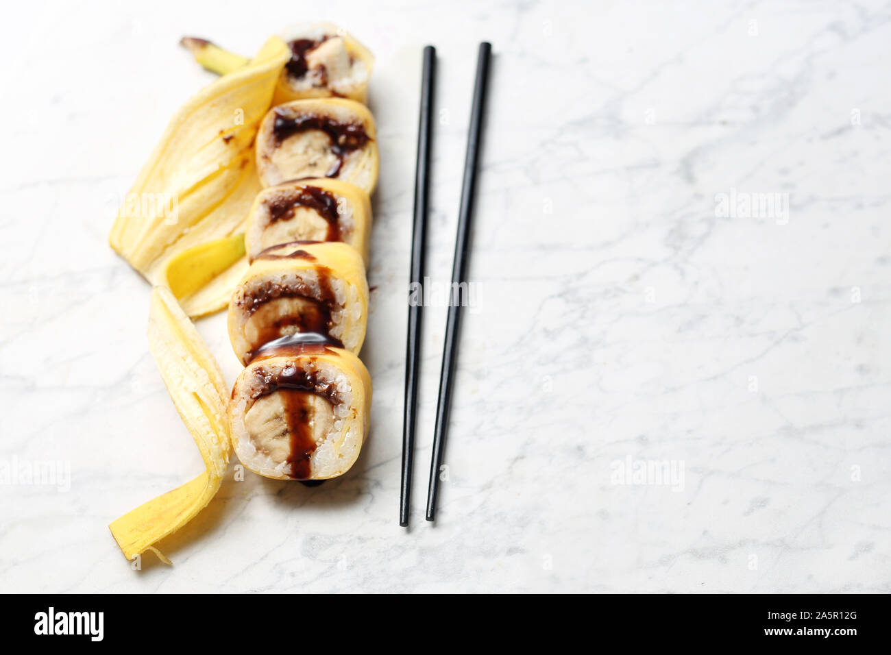 Obst Sushi, eine Rolle von Sushi mit Banane und Schokolade. Stockfoto
