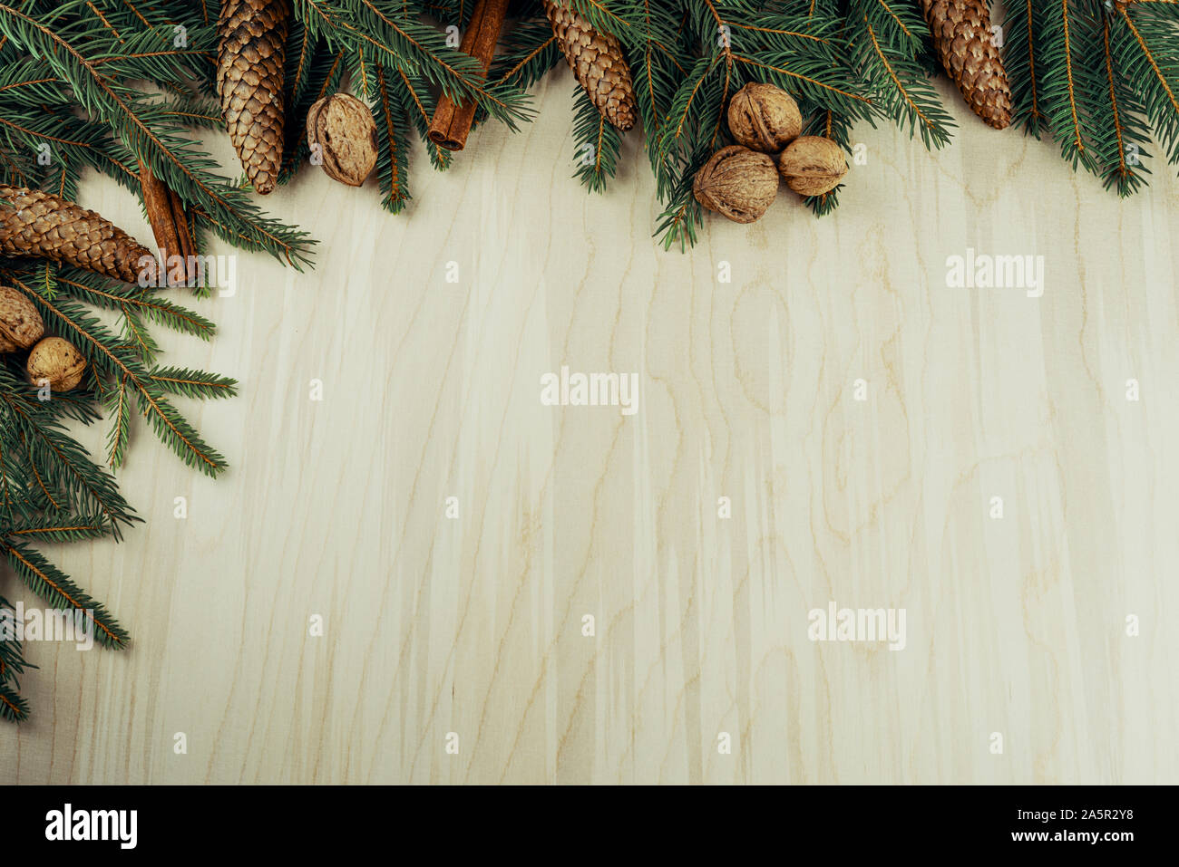 Weihnachten Rahmen mit Zweigen, Zapfen, Nüssen und Zimt auf Holz- Hintergrund gemacht Stockfoto