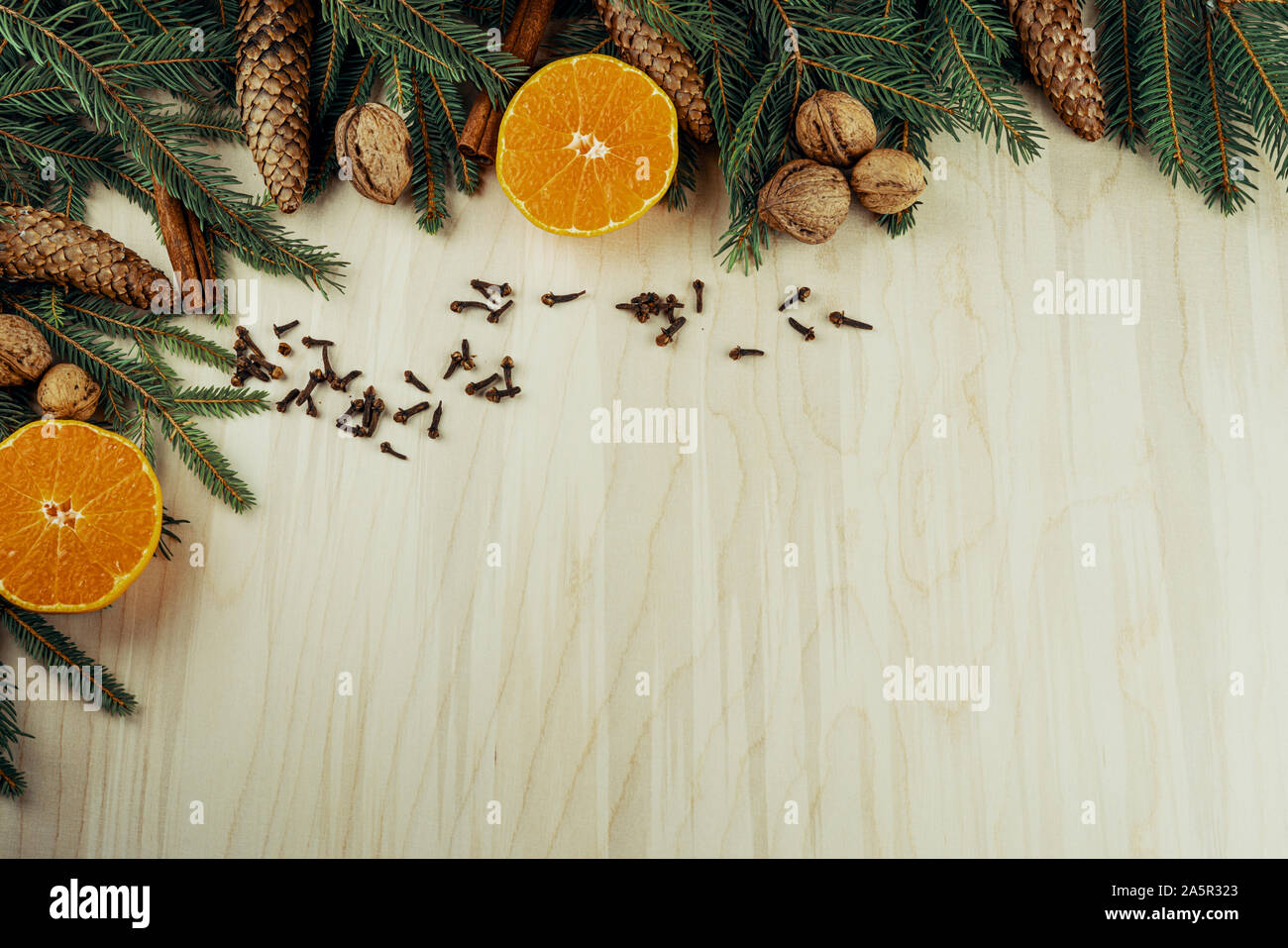 Weihnachten Rahmen mit Zweigen, Zapfen, Nüssen, Zimt, Nelken und Zitrusfrüchten auf hölzernen Hintergrund gemacht Stockfoto