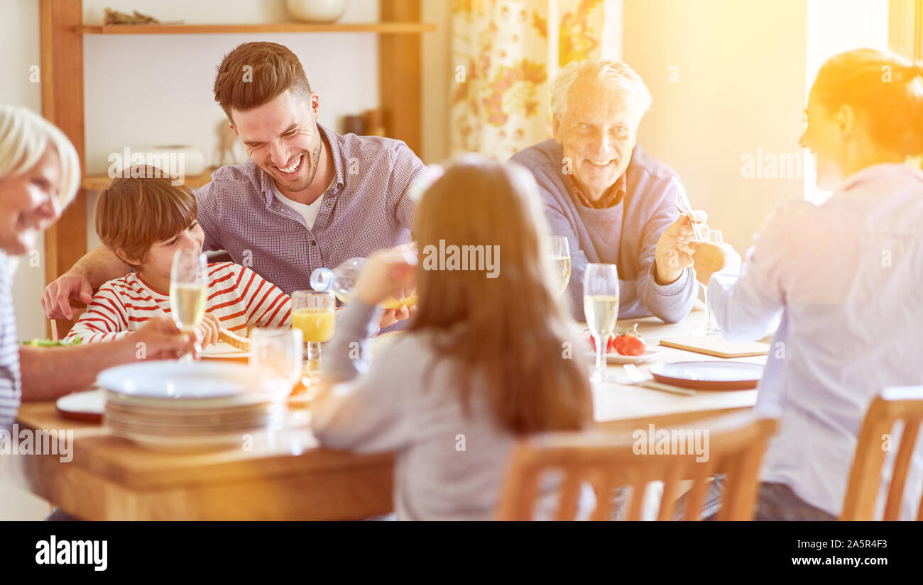 Erweiterte Familie mit Kindern und Großeltern sitzen am Tisch über dem Mittagessen Stockfoto