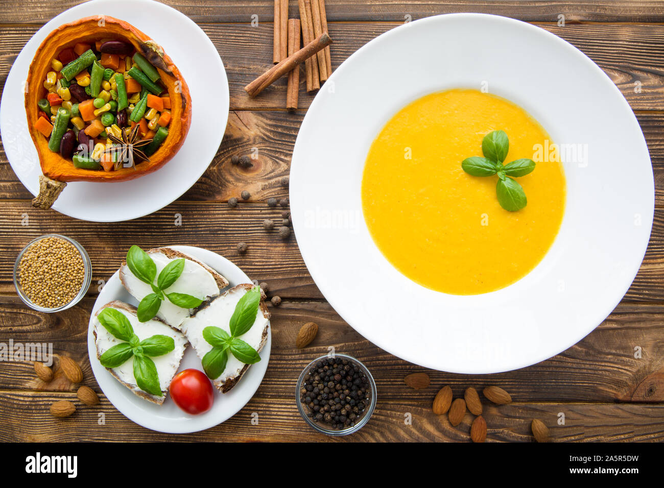 Kürbis creme Suppe mit Basilikum, gebackener Kürbis mit Gemüse: Karotten, Bohnen, Weiße, Bruschetta mit Frischkäse und Tomaten. Danksagung Stockfoto