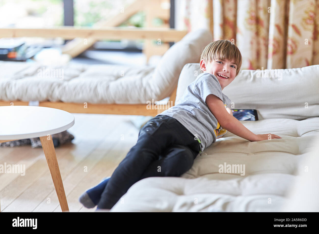 Happy Boy hat Spaß mit video Spiel auf dem Smartphone auf der Couch Stockfoto