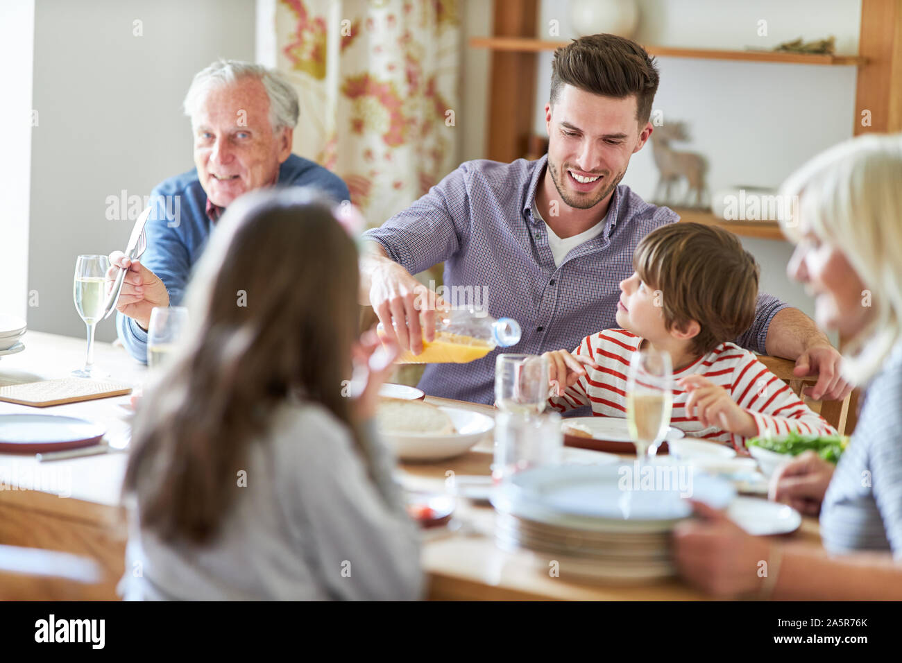 Erweiterte Familie in Abend- oder Mittagessen mit Großeltern und Enkel Stockfoto