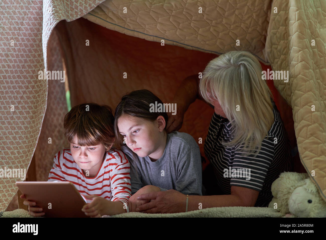Oma und Enkel Kinder mit e-Book oder Tablet Computer gemütlich in der Hütte Stockfoto