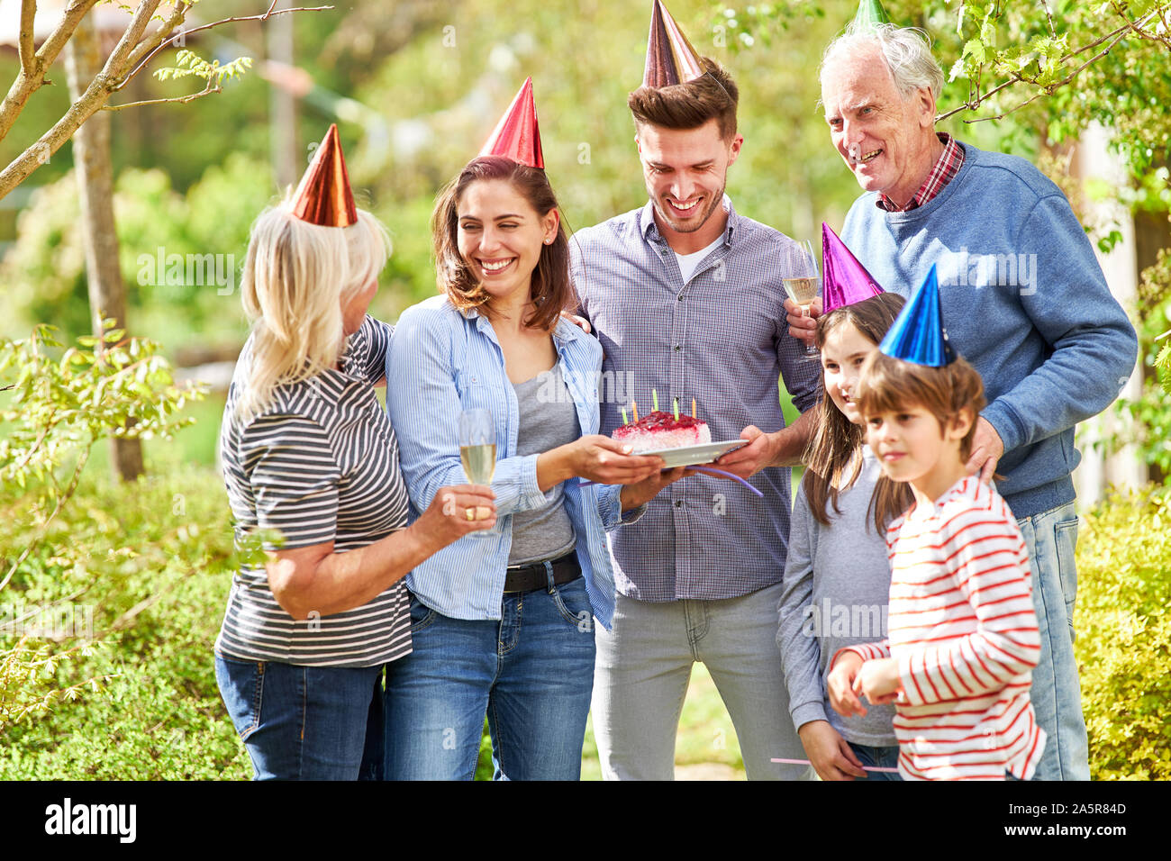 Erweiterte Familie mit Großeltern und Kinder feiert Geburtstag im Sommer im Garten Stockfoto