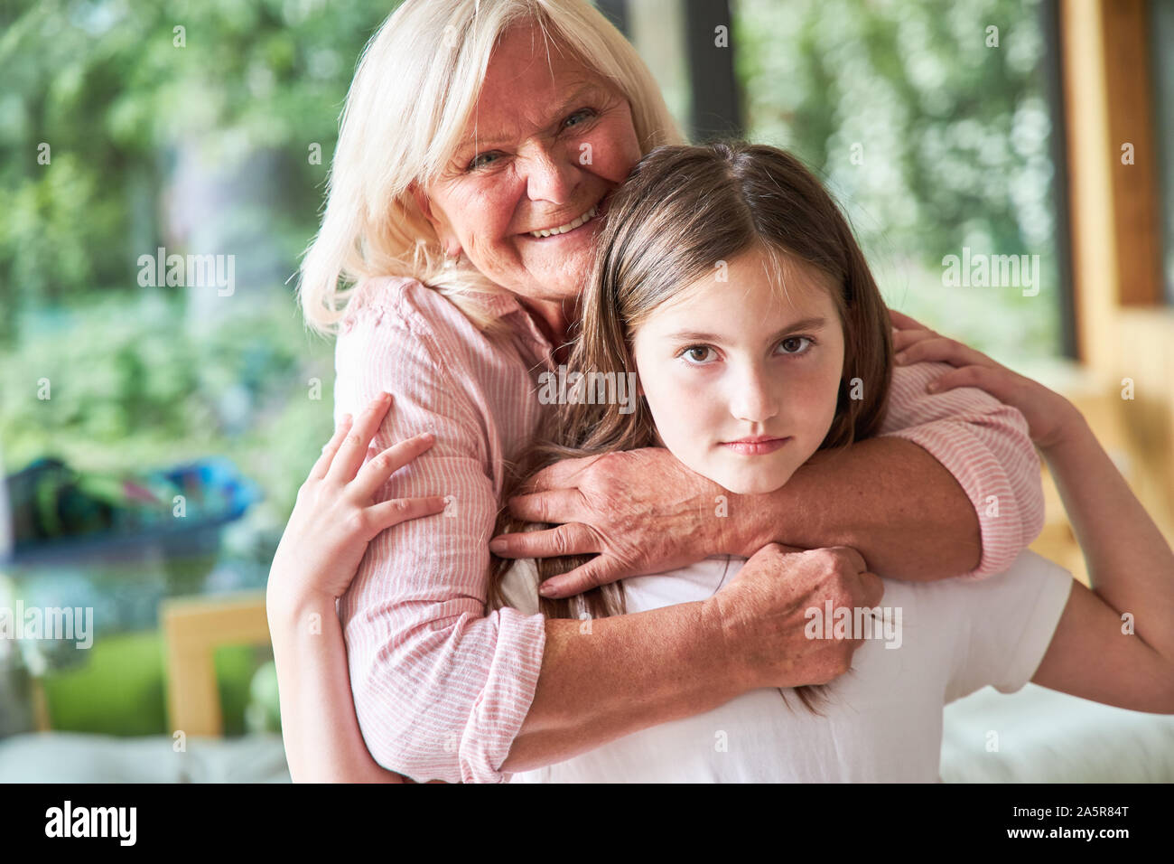 Familie mit Großmutter und Enkelin in der liebevollen Umarmung Stockfoto