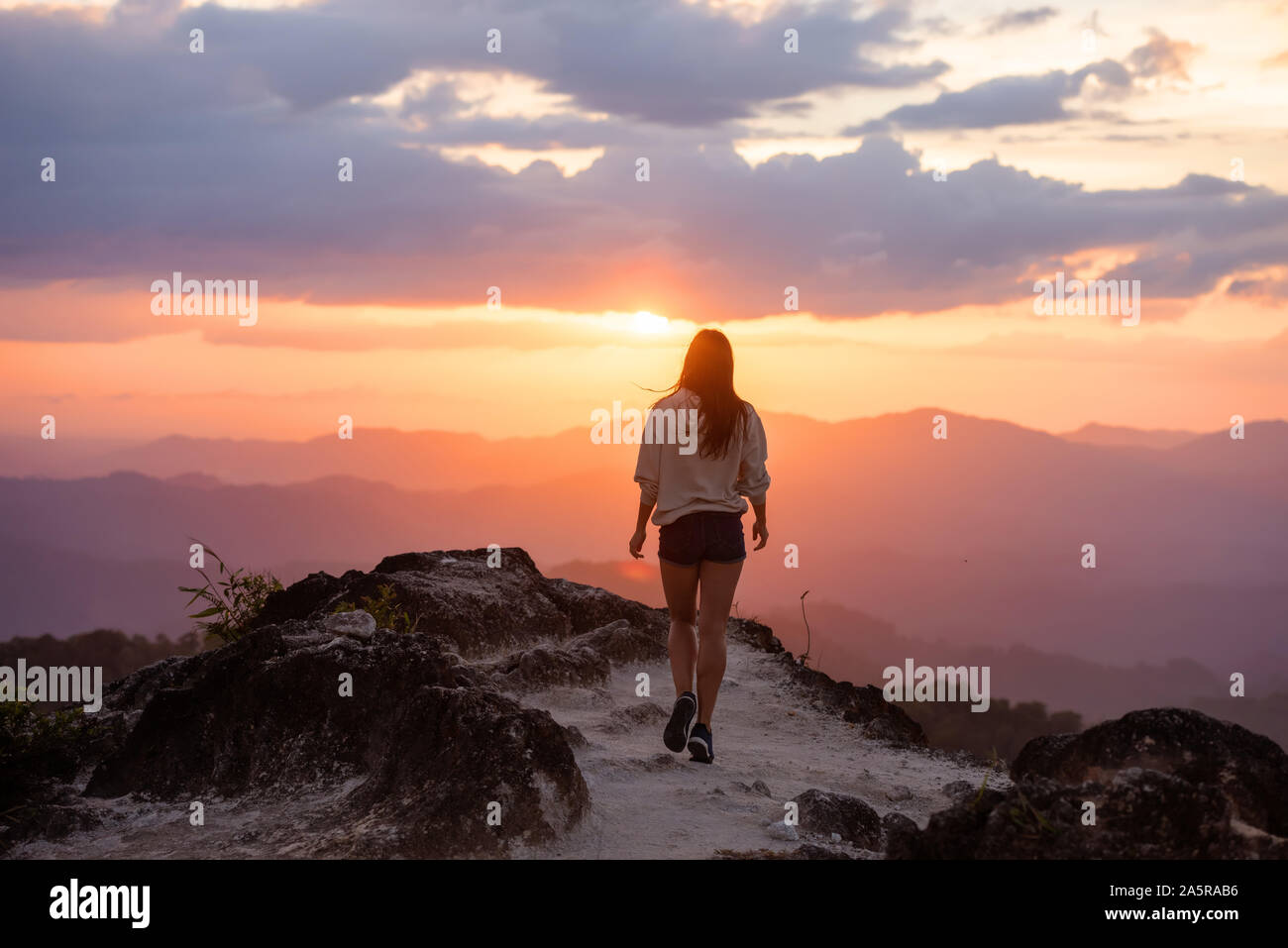 Schlanke schöne Mädchen Spaziergänge in Berge bei Sonnenuntergang. Travel Concept Stockfoto